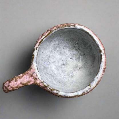 Ceramic cup with a handle on a gray background